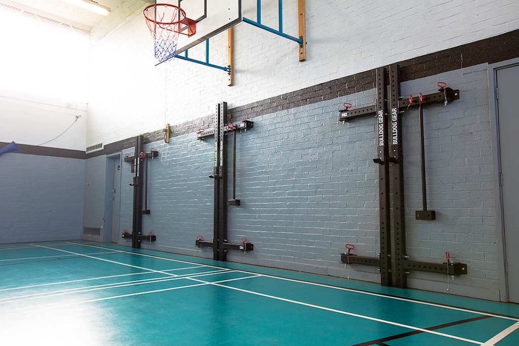 Bulldog Gear lite wall mounted folding rack installed in multi use sports hall.