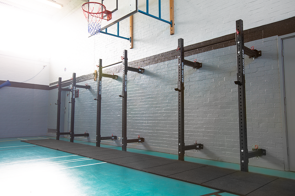 Bulldog Gear mammoth lite wall mounted folding rack installed in multi use sports facility.