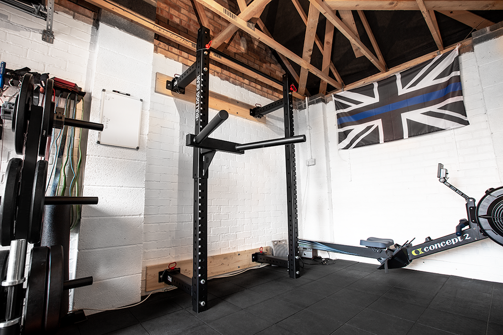 Bulldog Gear mammoth lite wall mounted folding rack installed in garage gym with dip attachment.