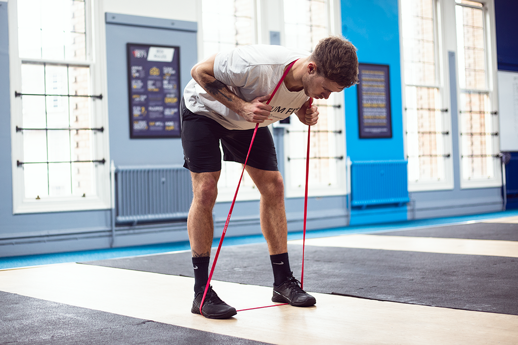 Man using Bulldog Gear light resistance band for banded good mornings